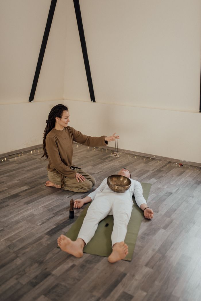 Therapeutic sound healing session using a Tibetan singing bowl for relaxation and meditation.