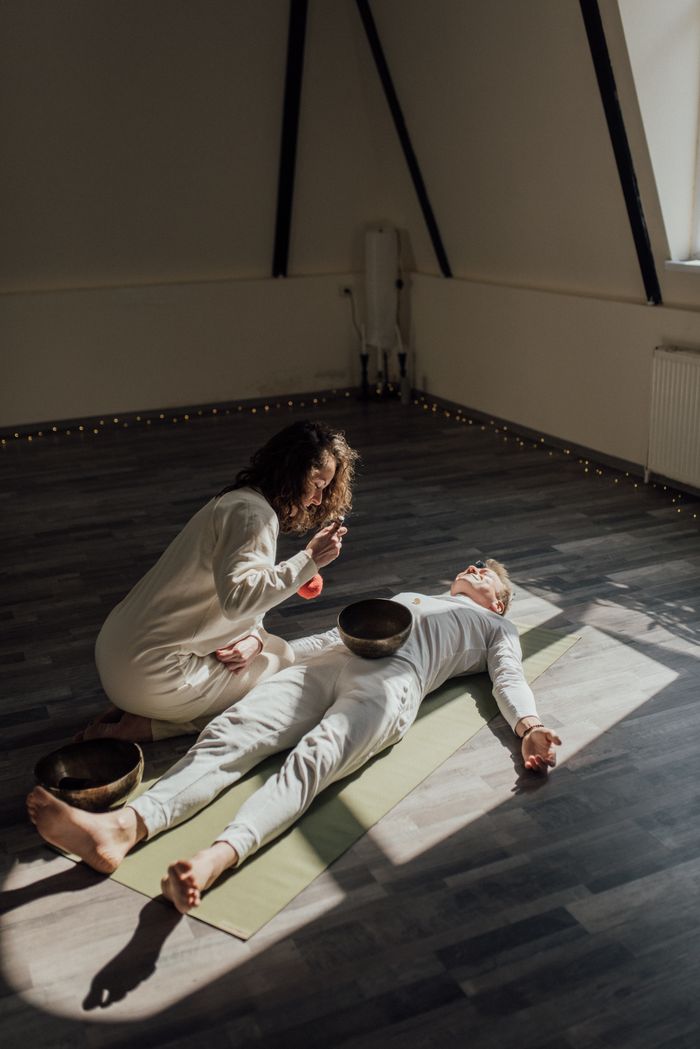 A sound healing session with singing bowls in an indoor setting promoting relaxation and wellness.